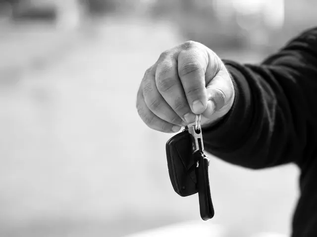 Locksmith holding a black car key fob on a ring