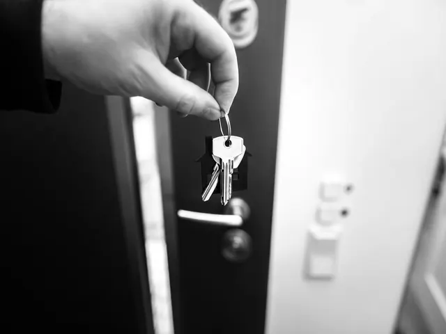 Locksmith holding a set of keys at a building front door